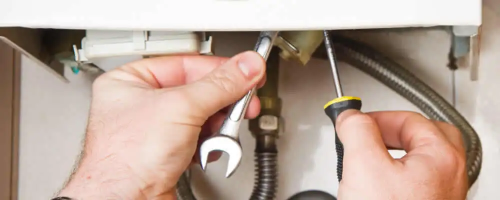 Boiler repair technician tightening pipe fittings and connections in Bloomington, IN