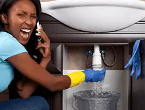 Emergency plumbing repair for a leaking sink drain under a bathroom vanity in Bloomington, IN