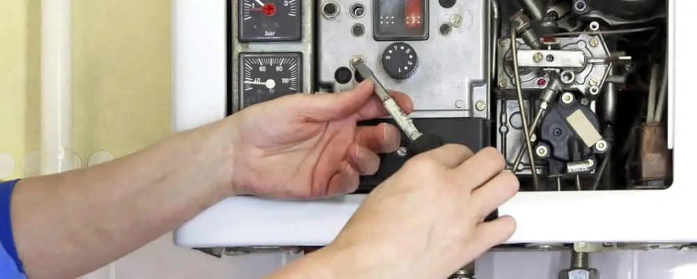 Heating repair technician adjusting boiler controls and components in Bloomington, IN