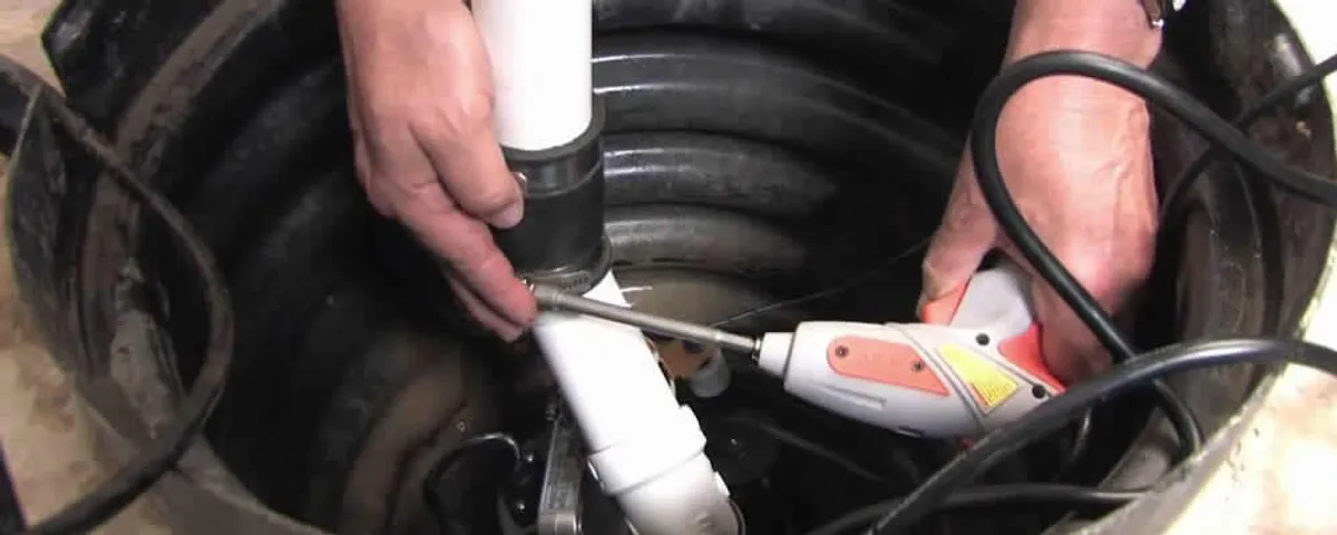 Sump pump installation technician connecting PVC discharge piping in Bloomington, IN